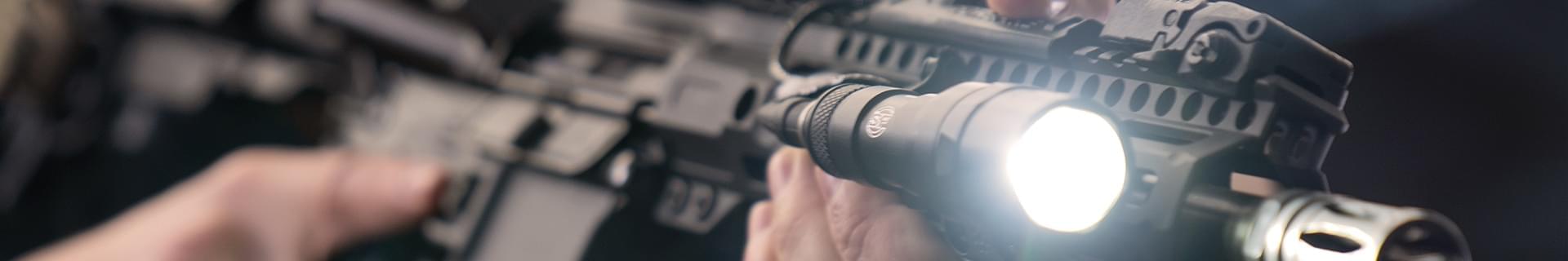 man shooting rifle with a flashlight