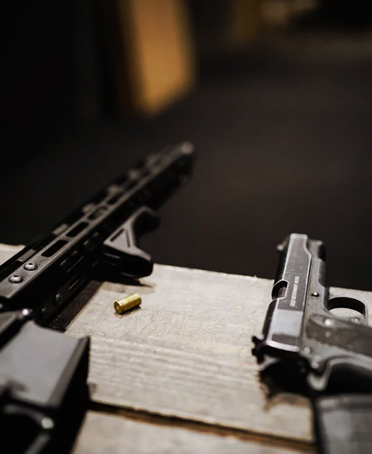 Carbine and handgun laying on bench